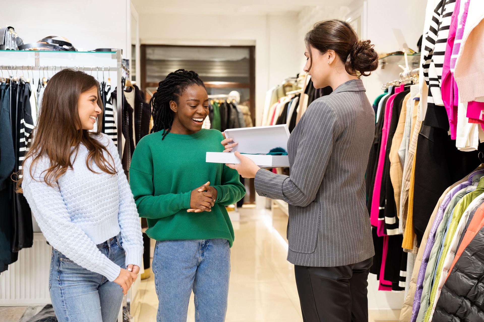 Happy Customers Shopping at Clothing Store with Salesperson